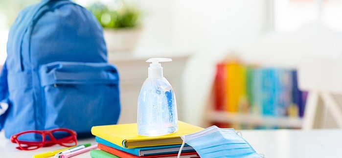 Backpack of school child with face mask and sanitizer. Student safety after coronavirus pandemic. Virus and disease prevention for kids. Back to school and kindergarten after covid-19 outbreak.