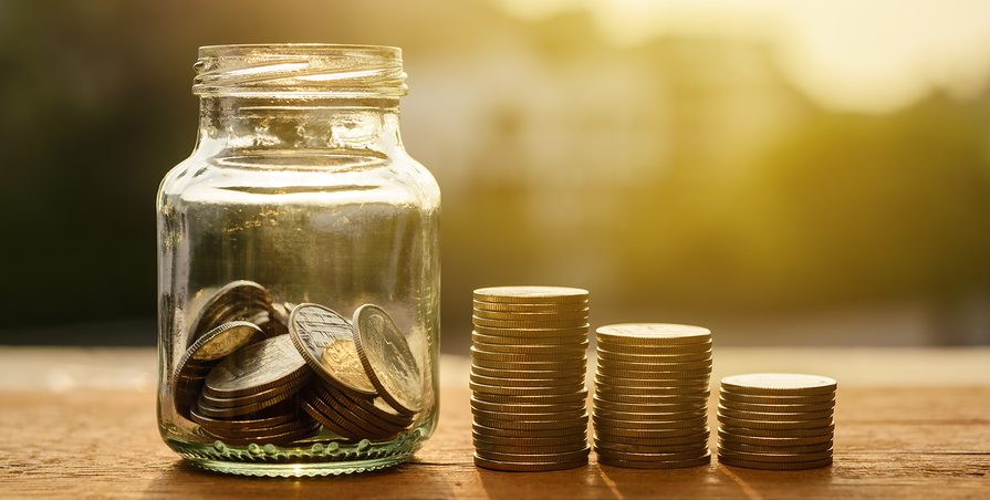 coins in a mason jar, saving money