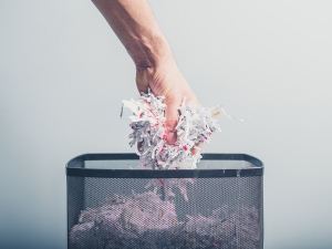 Hand Putting Shredded Paper In Basket